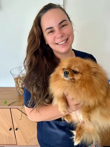 Integrante da equipe RAD com um cão lulu-da-pomerânia no colo